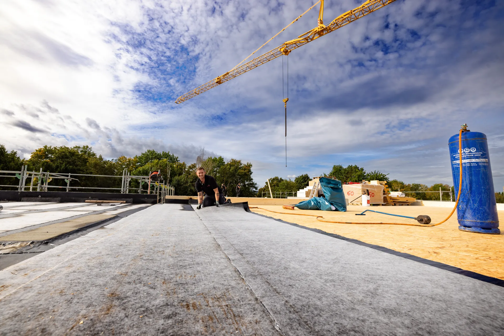 Zwei Männer kontrollieren und messen Dachziegel auf einem alten Dach.