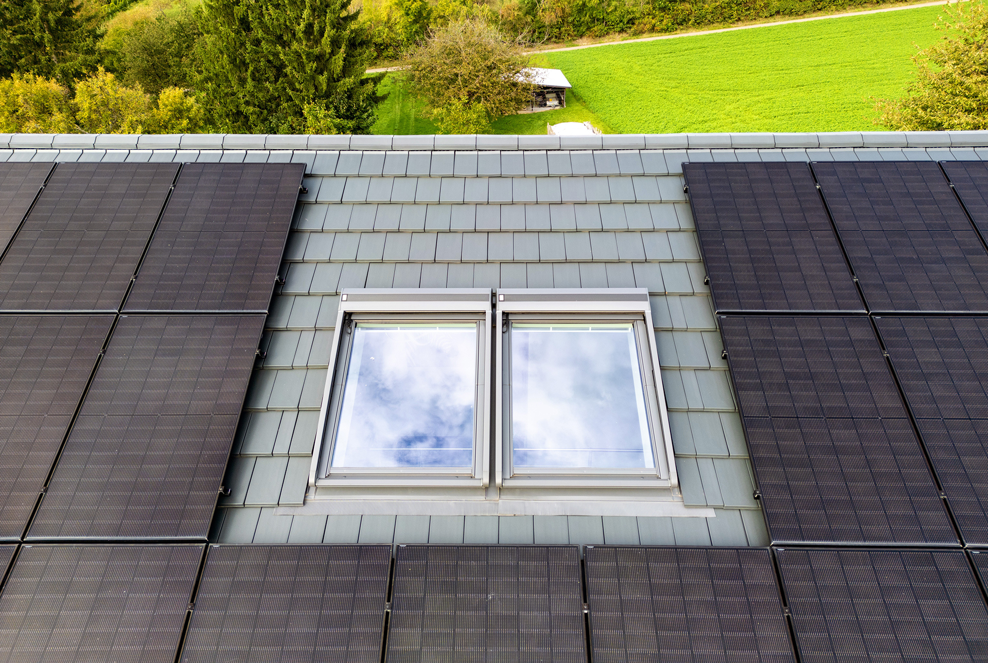 Zwei neue Dachfenster sind in ein Ziegeldach eingebaut.